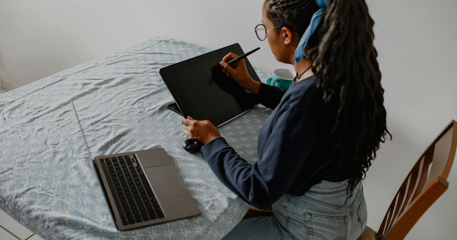 Entrepreneur working on website refresh strategy using tablet and laptop for small business site